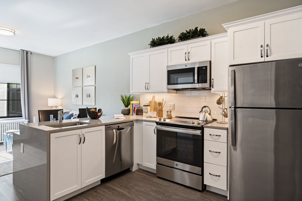 A modern kitchen featuring stainless steel appliances and white cabinetry.