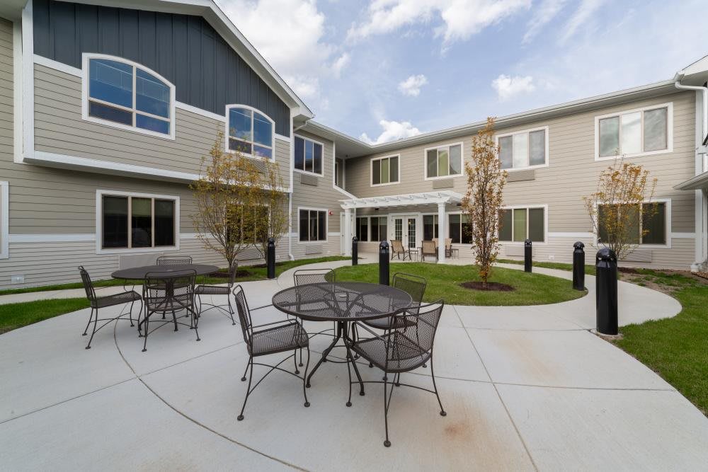 A view of a residential building's courtyard with patio furniture.