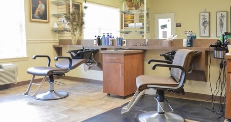 A cozy hair salon interior with modern chairs and styling stations.