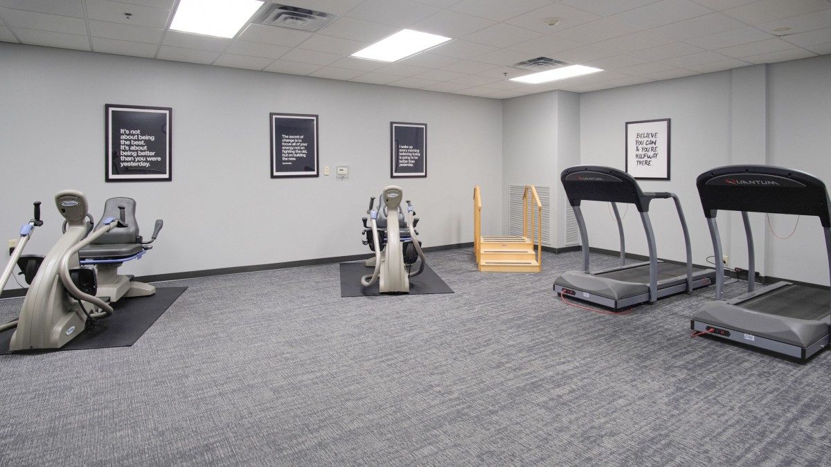 A small gym with exercise equipment including a treadmill and a stationary bike.