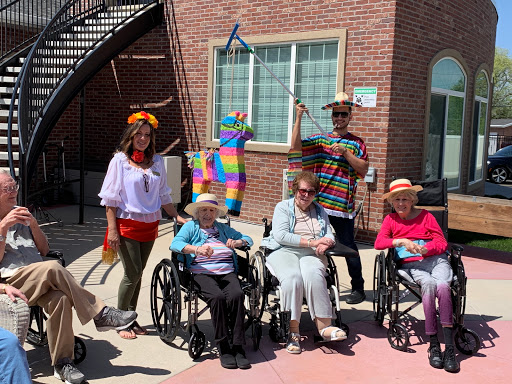 A joyful moment shared among residents and staff at a care facility, celebrating with colorful attire and fun activities.