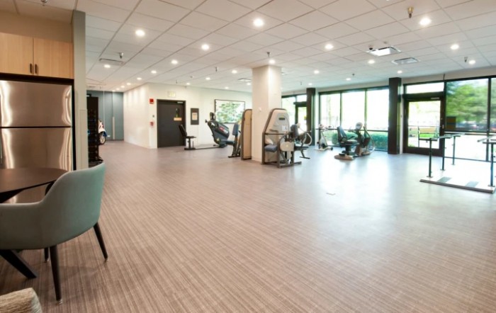 A spacious and modern gym featuring various exercise equipment.