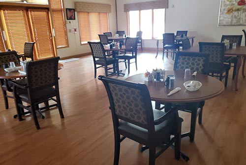 An empty dining area in a restaurant with neatly arranged tables and chairs.