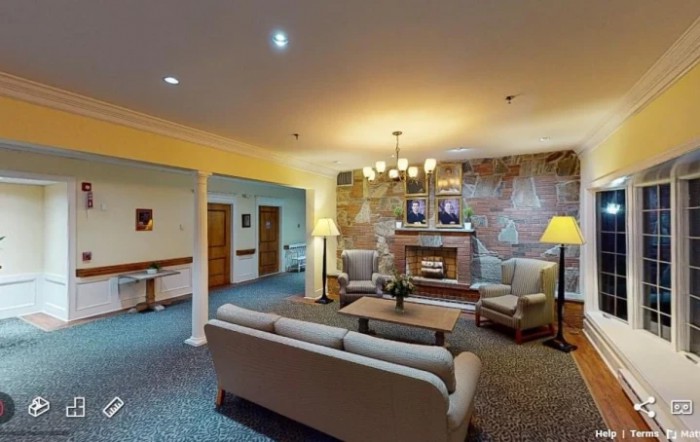 A cozy living room with sofas, lamps, and a fireplace.