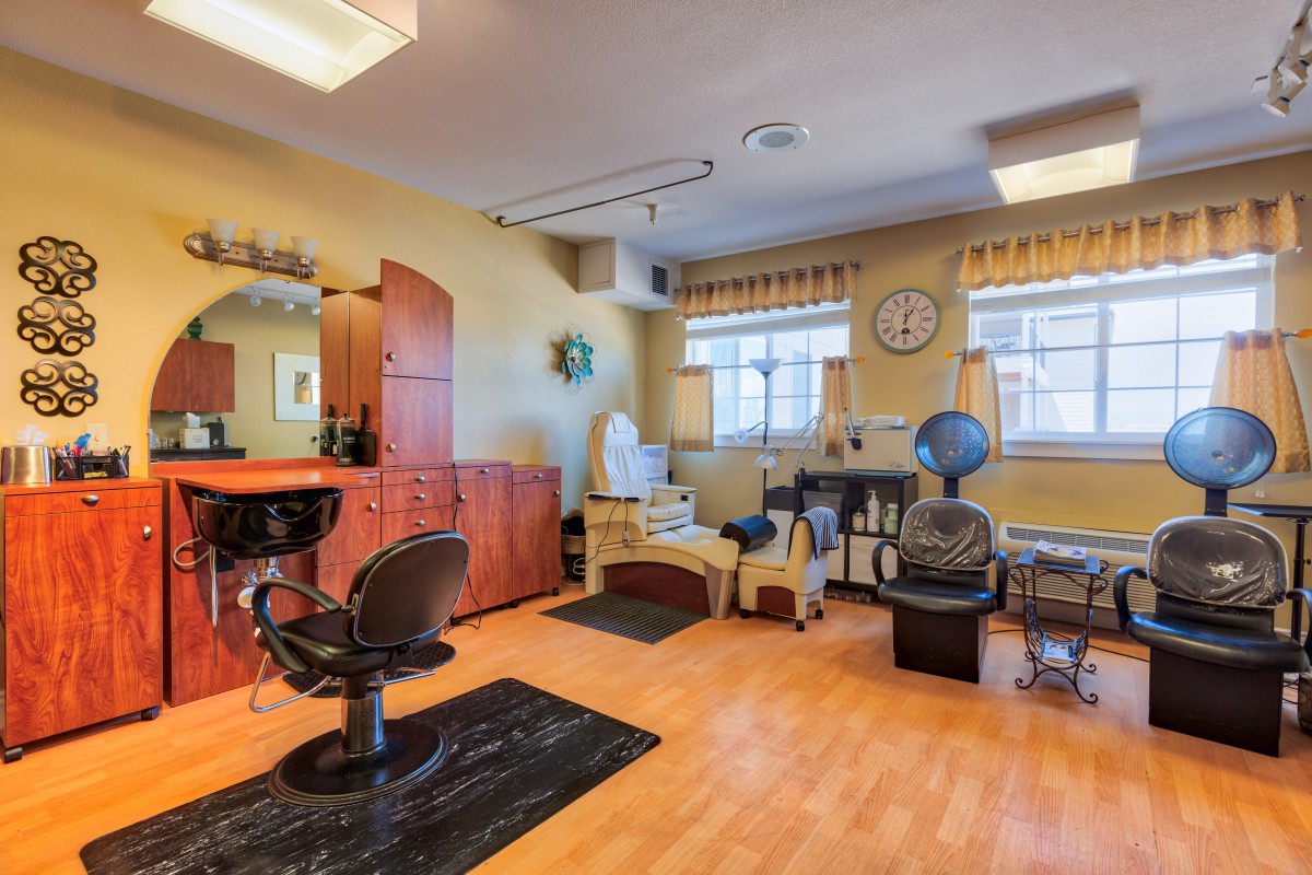A cozy hair salon interior with styling chairs and equipment.