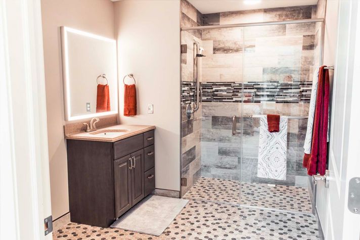 A modern bathroom with a glass-enclosed shower and a vanity featuring an illuminated mirror.