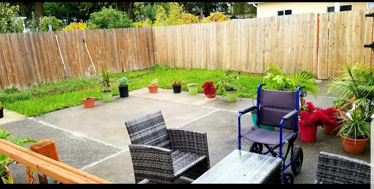 A cozy backyard patio with outdoor seating and potted plants.