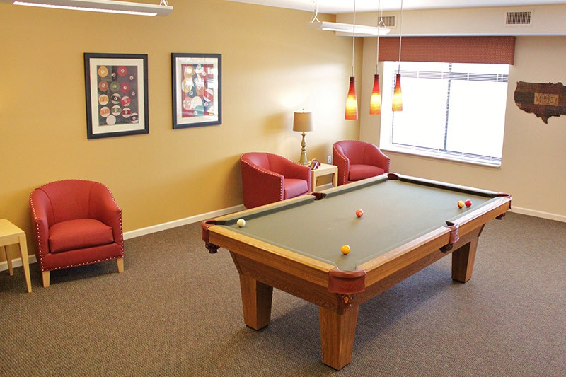 A cozy game room featuring a pool table and comfortable seating.