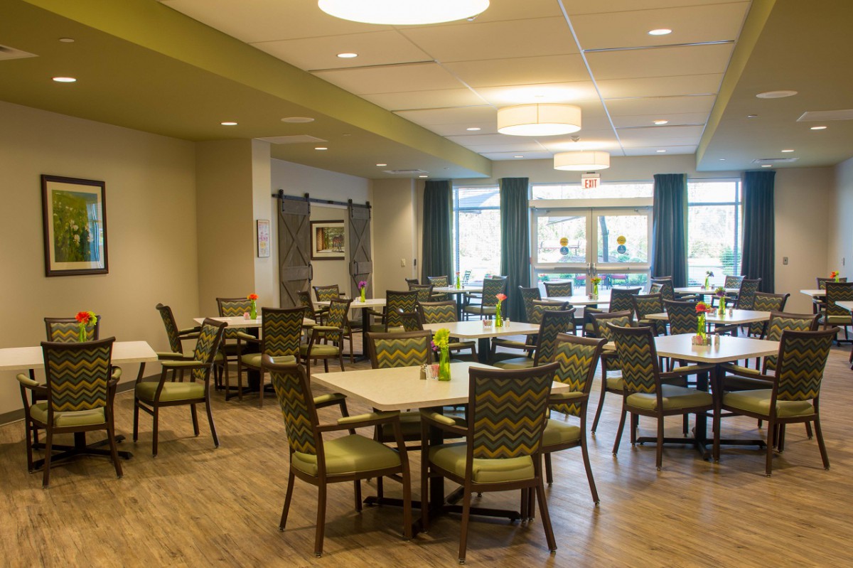 A modern dining area with neatly arranged tables and chairs, featuring contemporary decor and ample lighting.