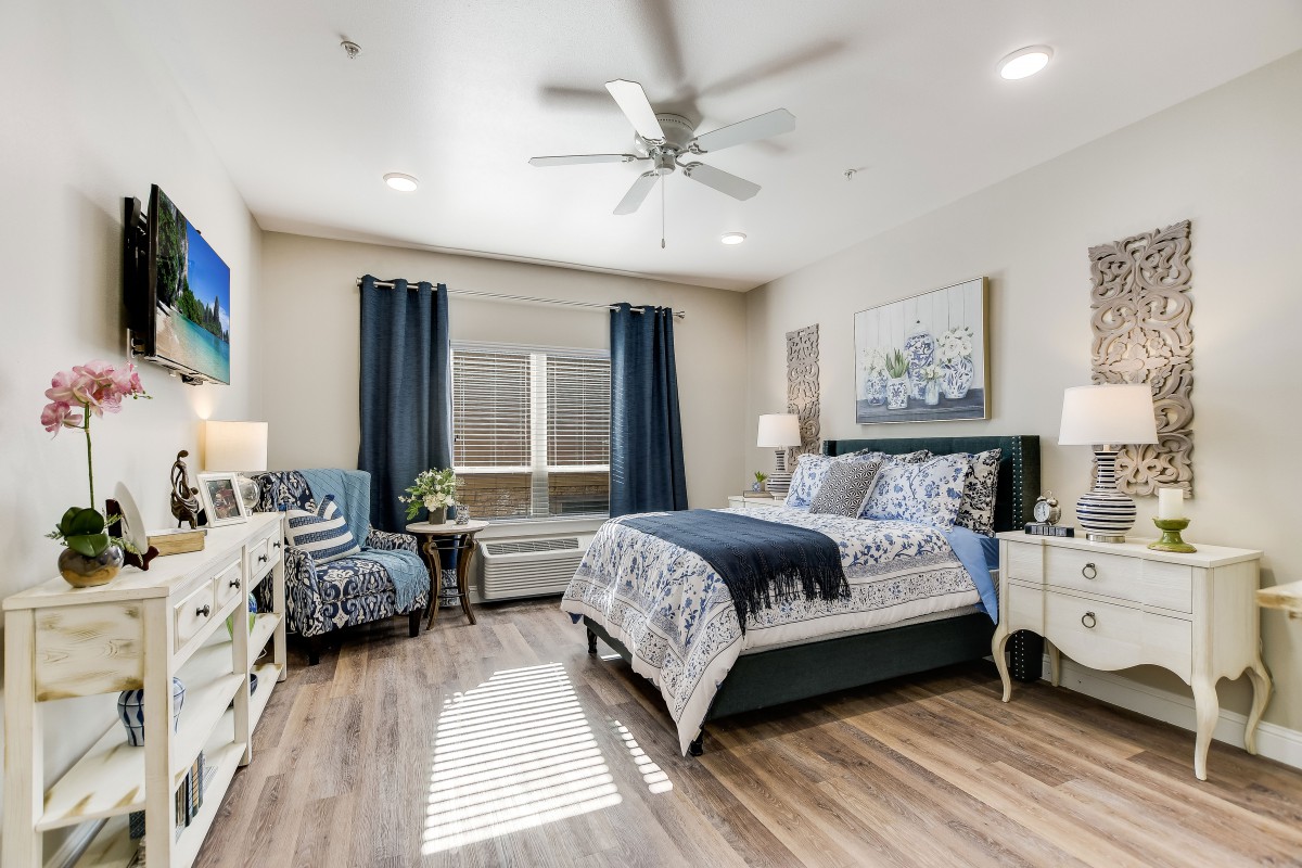 A modern bedroom with elegant decor, featuring wood flooring and stylish furnishings.