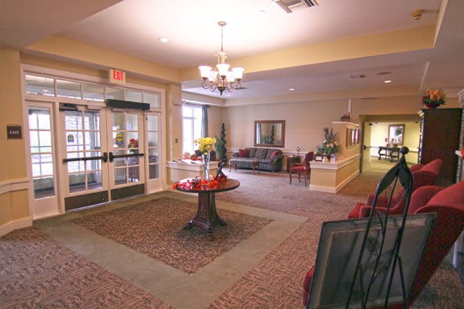 A cozy lobby with a central table, comfortable seating, and elegant decor.