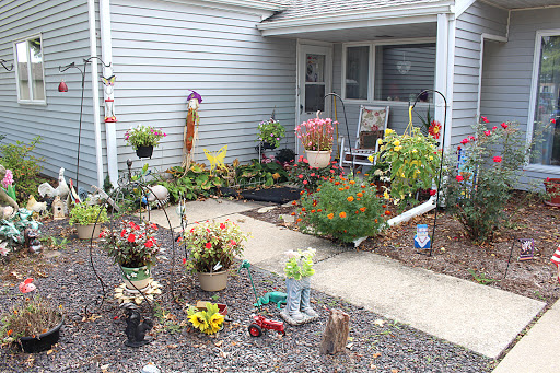 A vibrant and well-maintained front garden filled with various flowering plants and decorative elements.