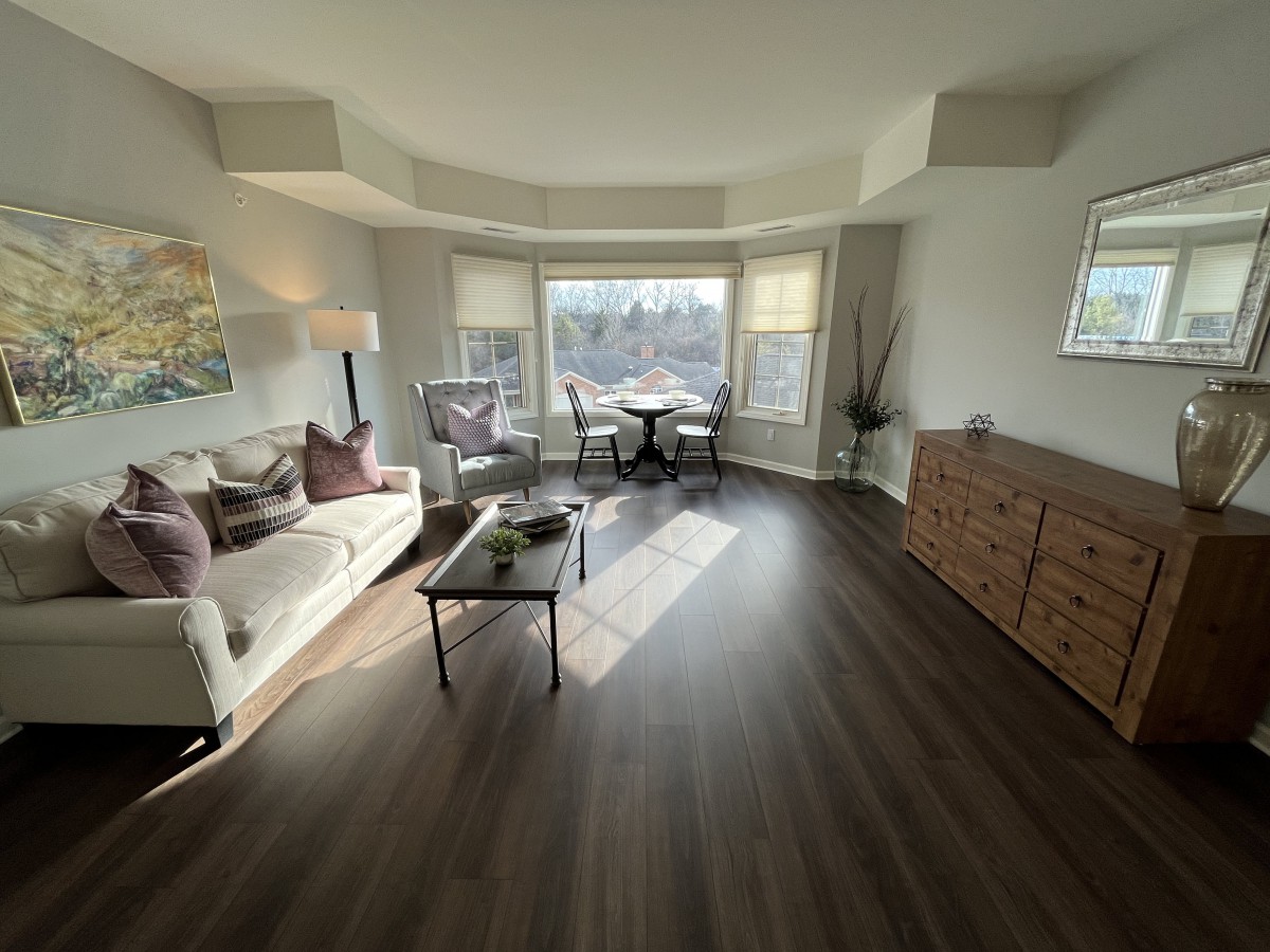 A sunlit modern living room with elegant decor and wooden flooring.