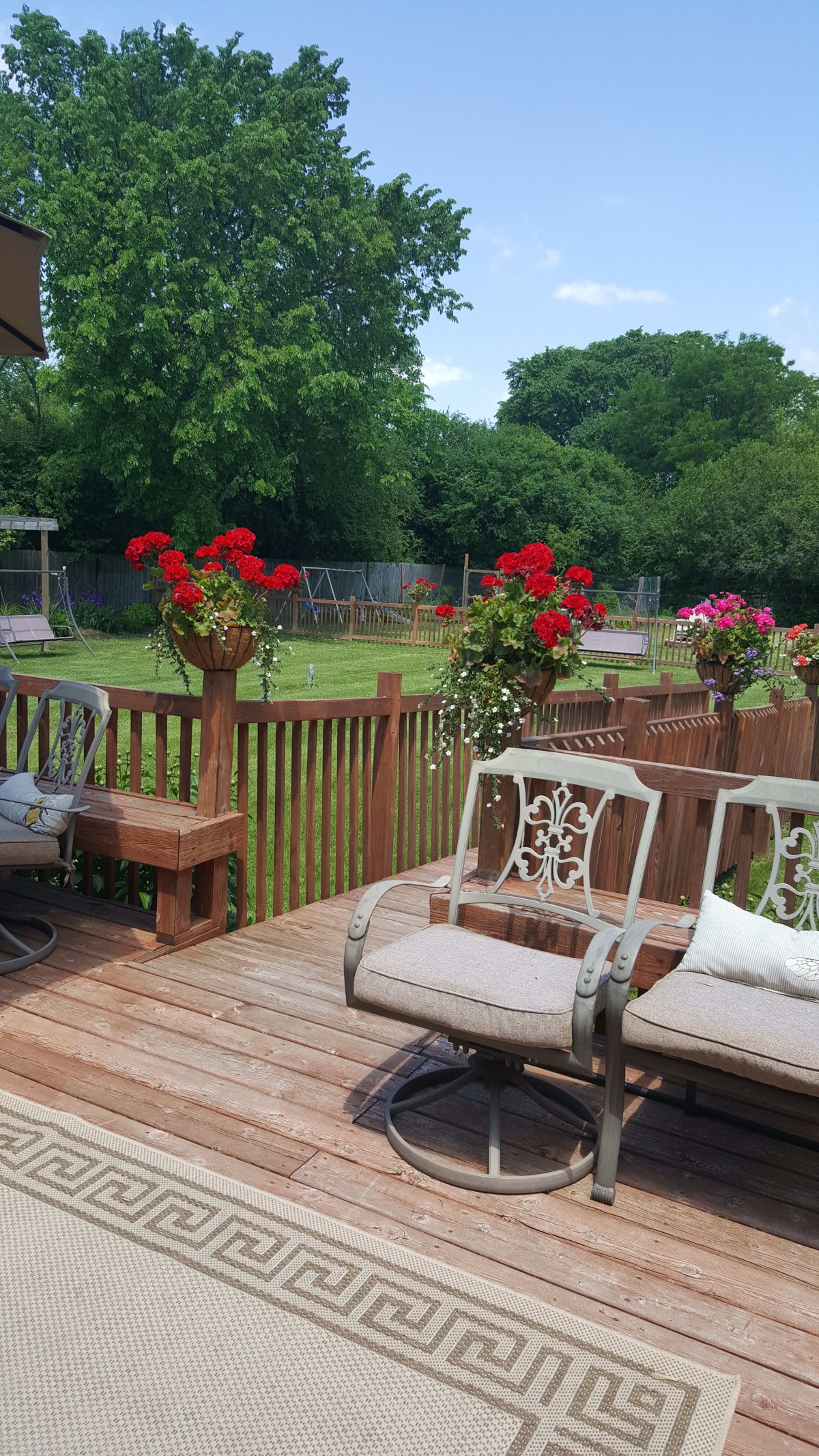 A cozy backyard deck with outdoor seating and vibrant flowers.