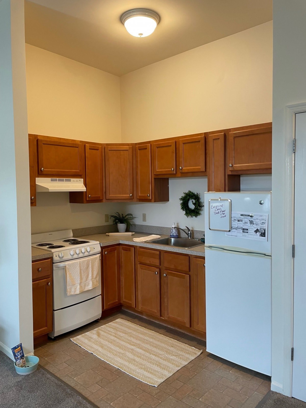 A cozy kitchen with wooden cabinets and standard appliances.