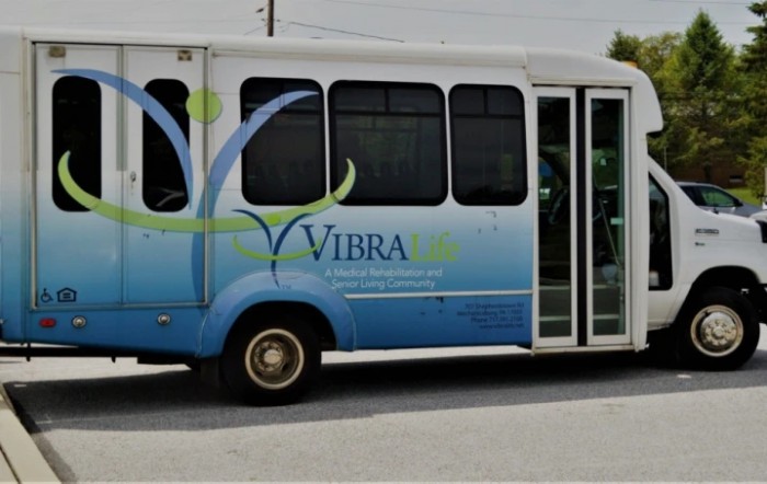 A blue and white Vibra shuttle bus parked on the street.