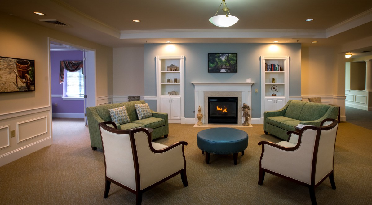 A cozy living room with a fireplace, comfortable seating, and traditional decor.