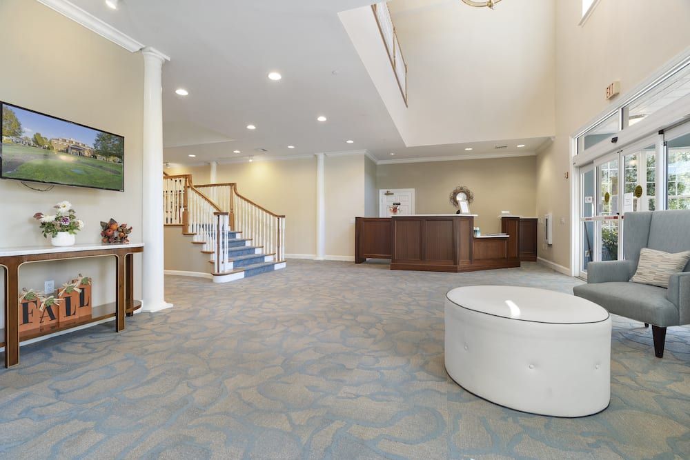 A spacious lobby with a reception desk and staircase.