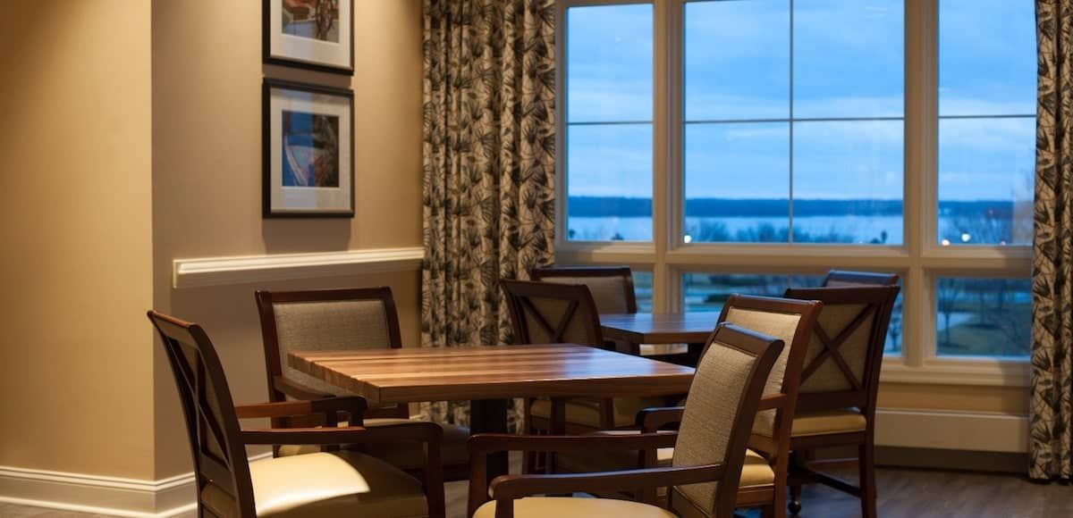 A cozy dining area with a wooden table and chairs, featuring a window with a scenic view.