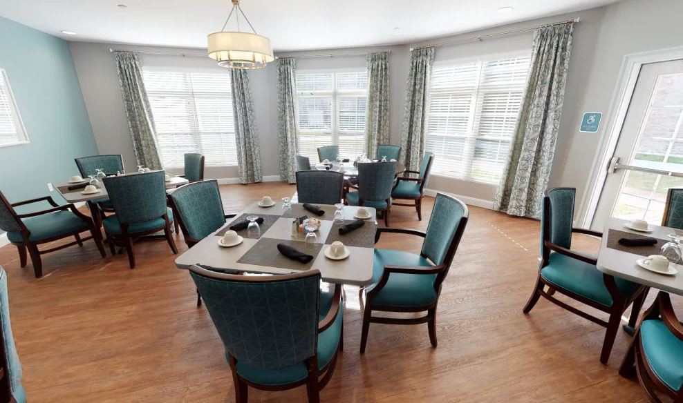A well-lit dining room with elegant dcor and multiple tables set for guests.