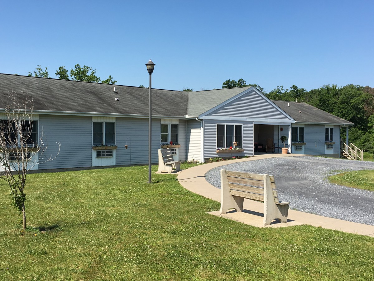 A residential building with a driveway and a well-maintained lawn.