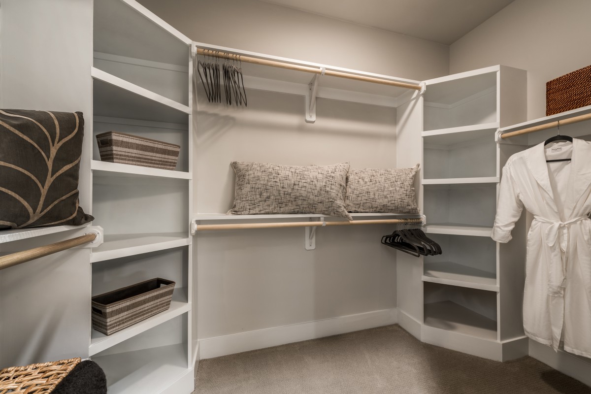 A well-organized walk-in closet with open shelves and ample storage space.