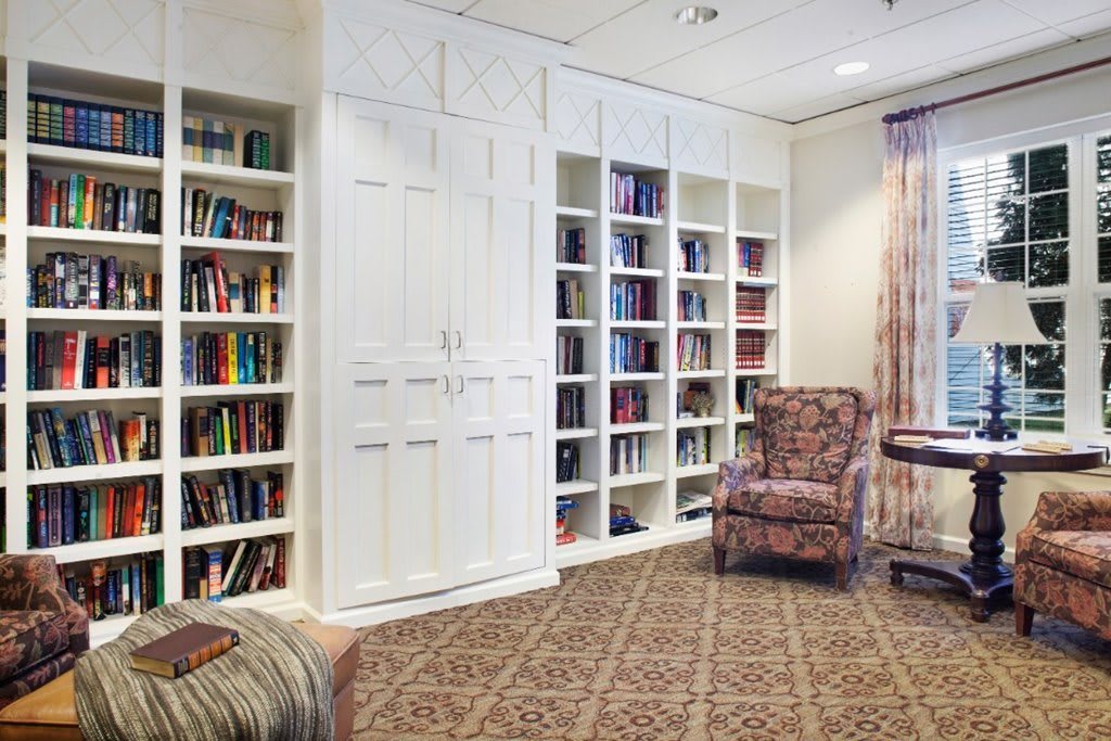 A cozy reading room with bookshelves and an armchair.