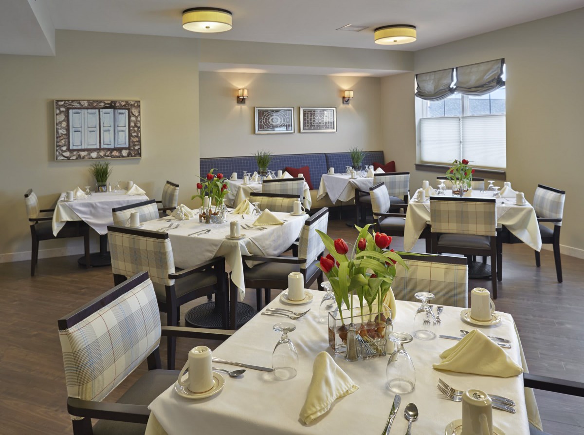 Elegant dining room with neatly arranged tables and floral centerpieces.