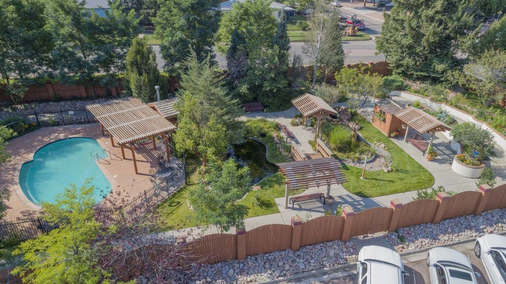 Aerial view of a landscaped garden with gazebos and pathways surrounded by greenery.