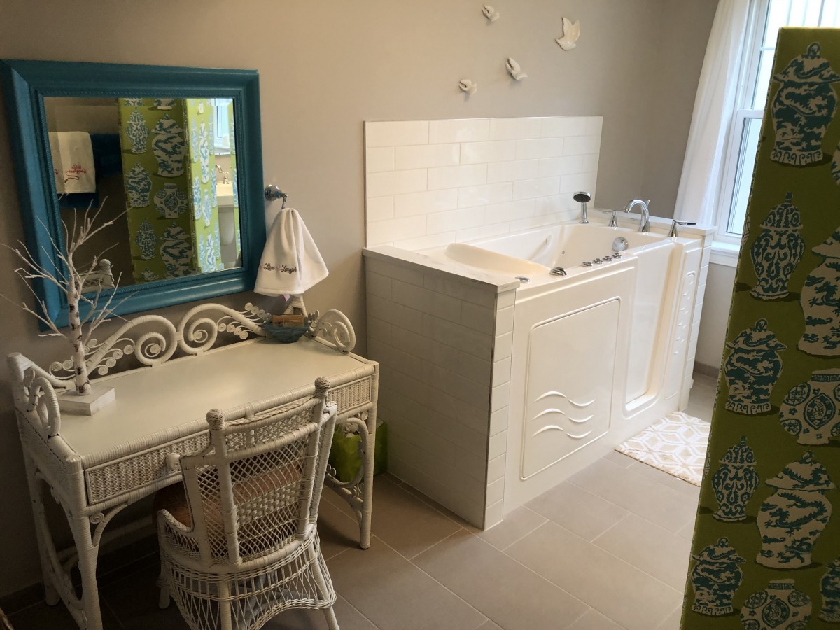 A stylish bathroom with a white vanity table and a walk-in bathtub.