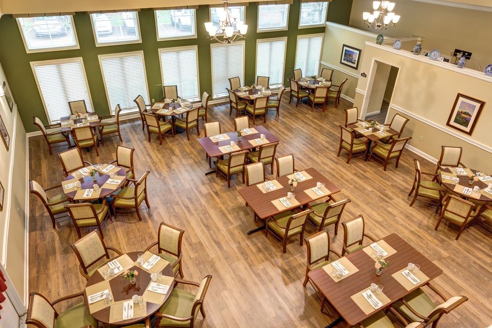 An elegant dining room with neatly arranged tables and chairs on a wooden floor.