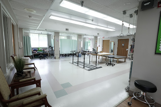 A spacious and well-lit rehabilitation room equipped for physical therapy.
