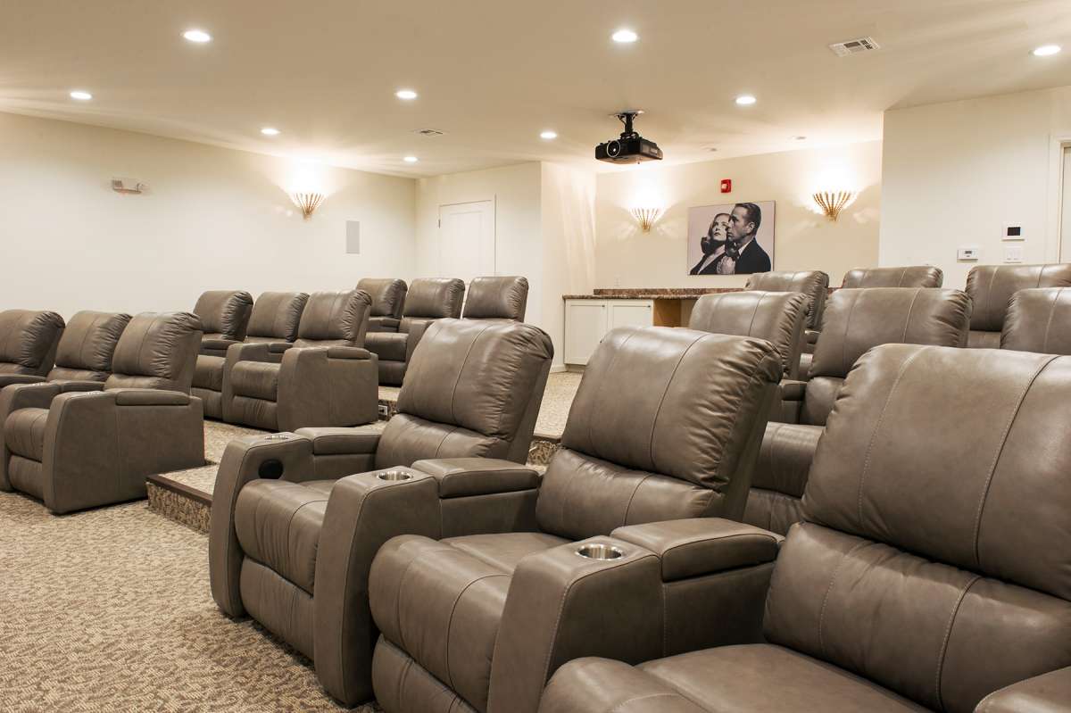 A luxurious home theater featuring comfortable recliner chairs and a projector setup.