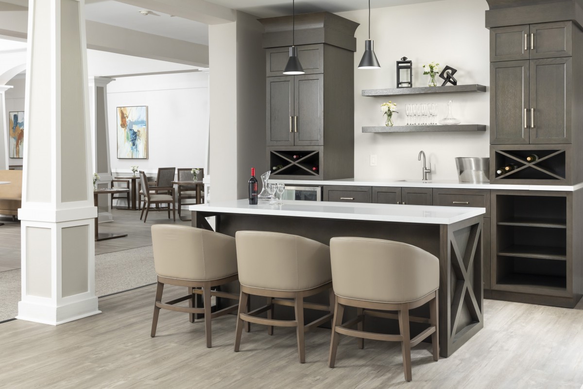 Modern kitchen with beige bar stools and minimalist decor.