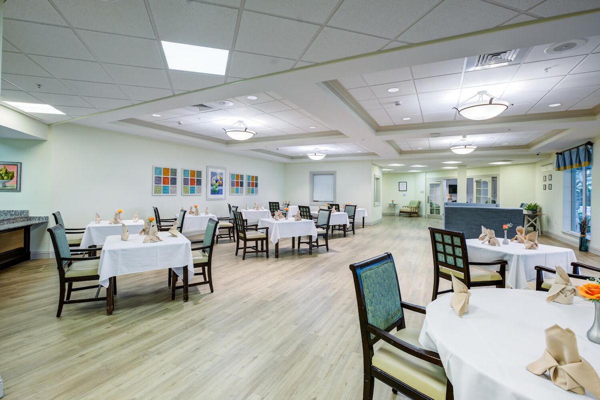 An empty dining room with neatly arranged tables and chairs.