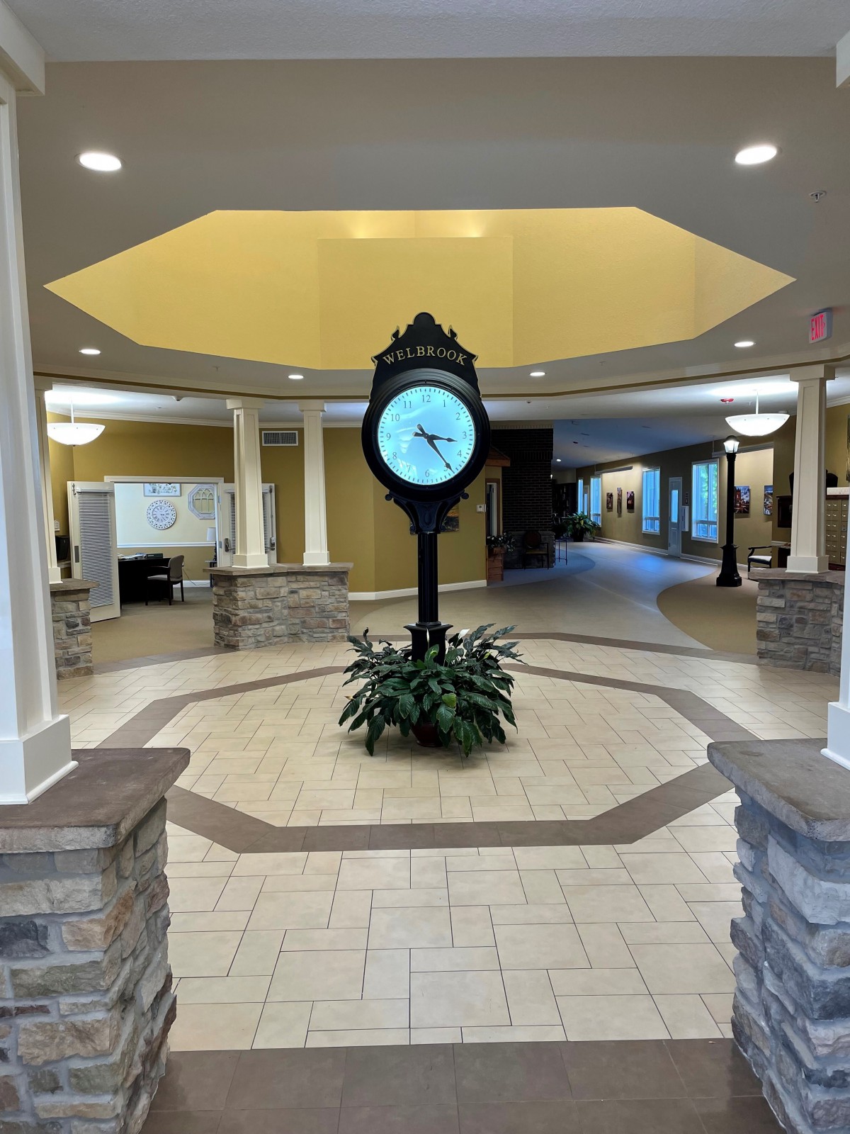 A spacious lobby with a central clock and elegant lighting.