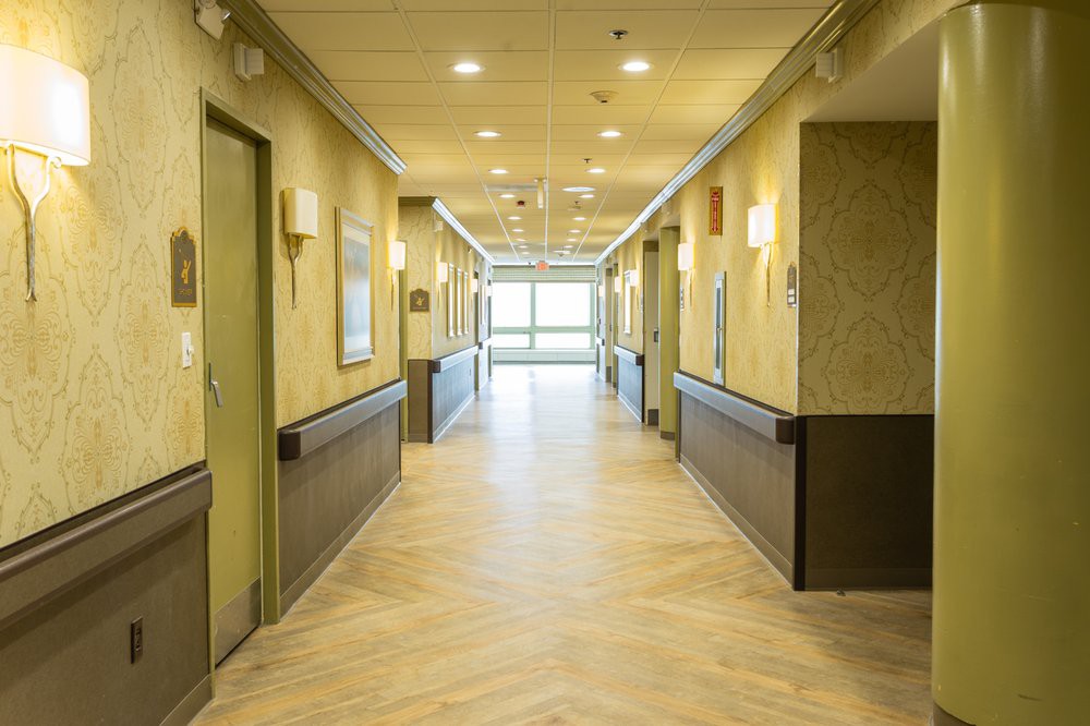 A well-lit hallway with multiple doors and a polished floor.