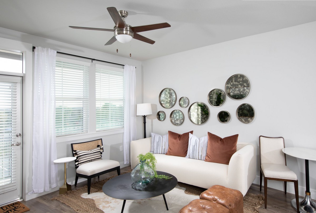 A modern living room with white walls, accented by circular mirrors and a comfortable sofa.