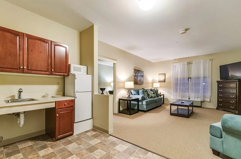 A cozy apartment interior featuring an open living room and kitchen area with comfortable furnishings.