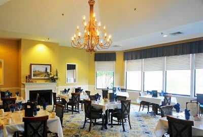 An elegant restaurant dining room with a chandelier and neatly arranged tables and chairs.