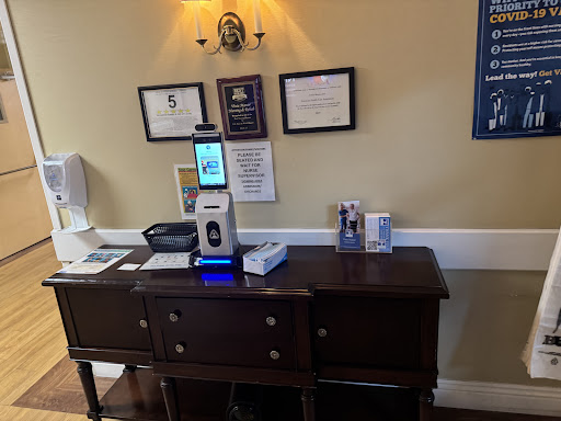 A reception area featuring a technology device for sanitization along with displayed certificates.