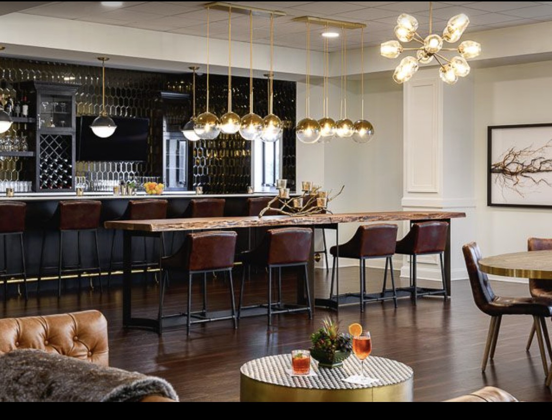 A modern and luxurious bar interior with elegant lighting fixtures and stylish seating.