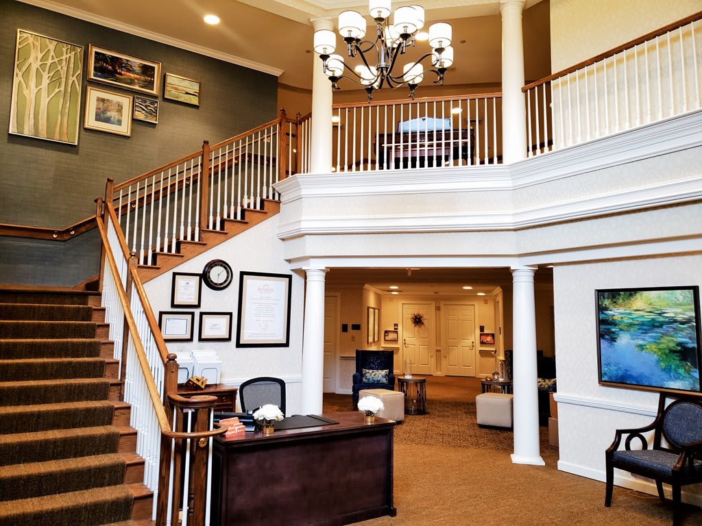 A spacious office lobby with a grand staircase and elegant chandelier.