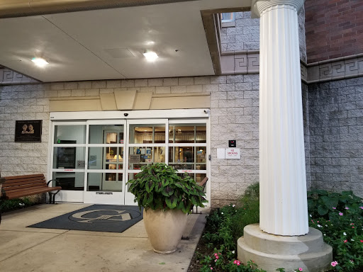 The welcoming entrance of a hotel, featuring a classic column and decorative plant.