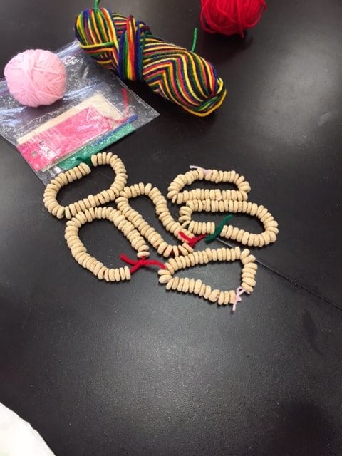 A collection of beaded bracelets with colorful yarn and materials.