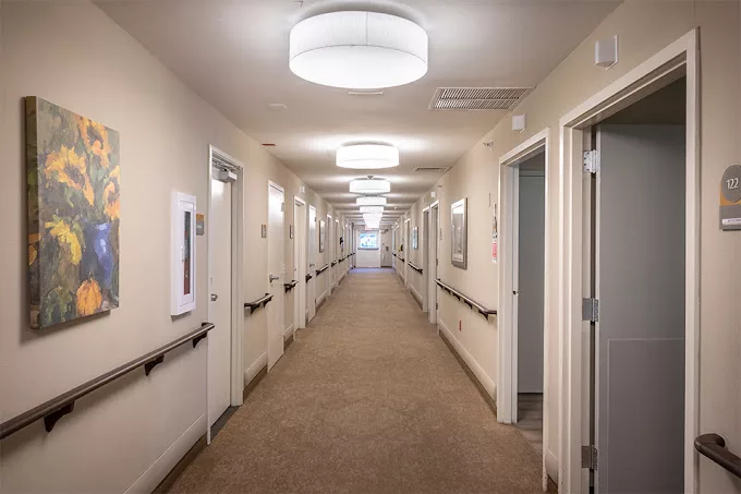 A well-lit interior hallway with multiple doors and modern fixtures.