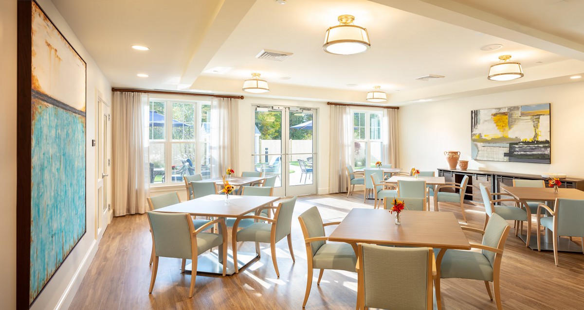 A bright and spacious dining room with modern furniture and large windows.