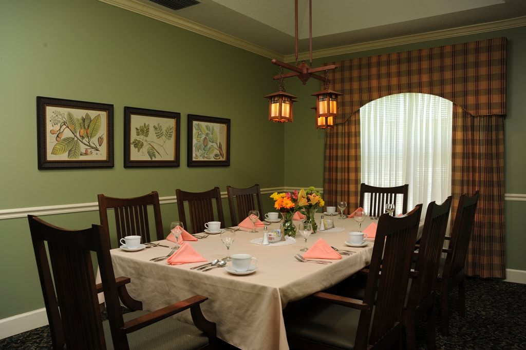 A beautifully set dining room table with floral decor and warm lighting.