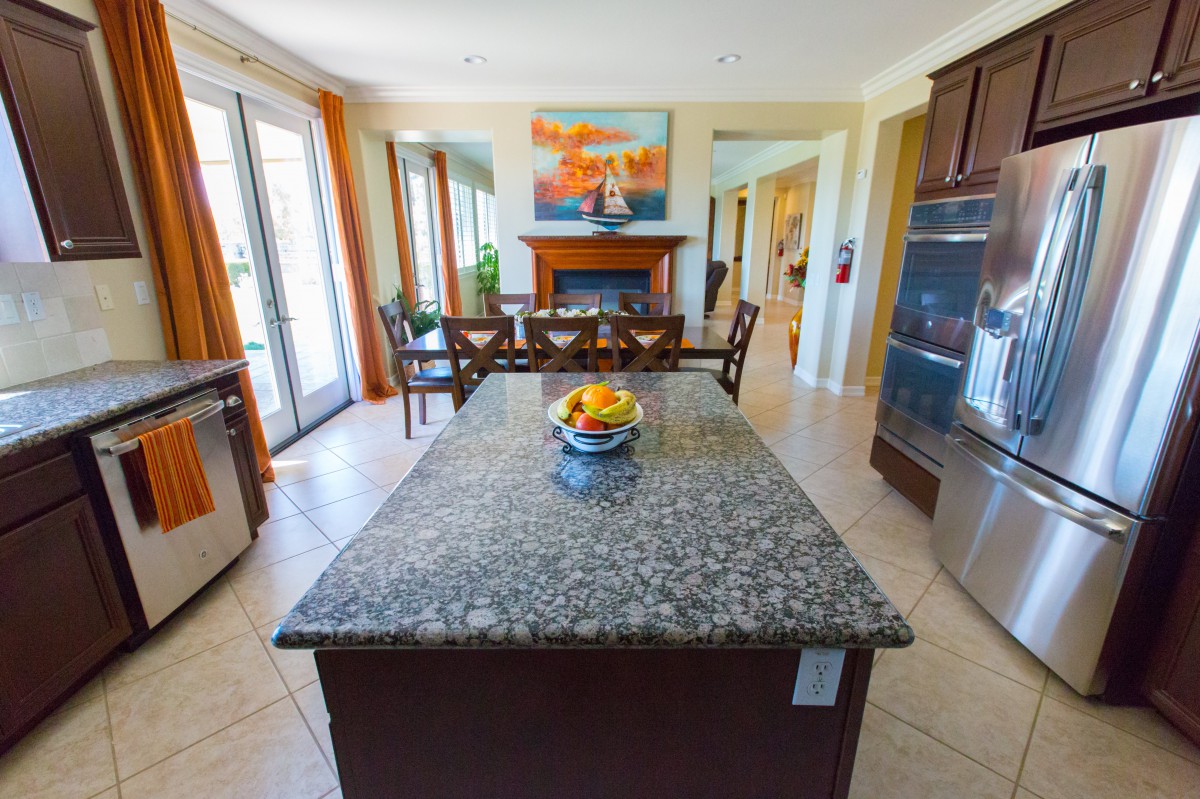 A modern kitchen with a granite island and colorful decor.