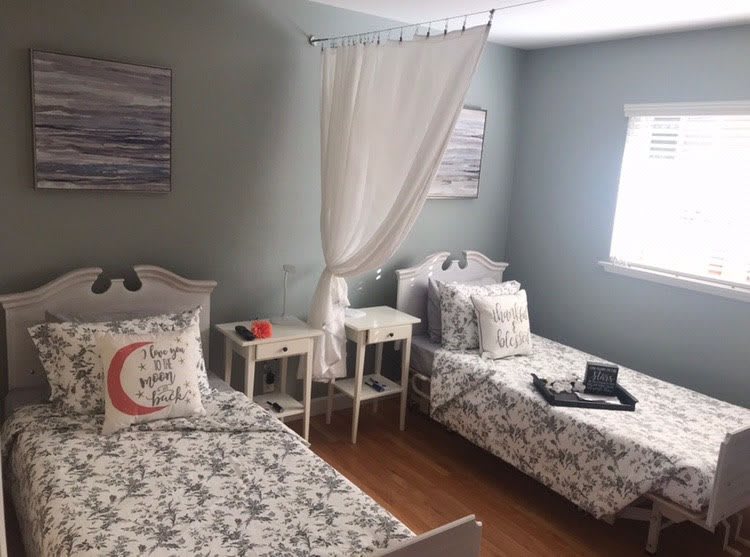 A cozy twin bedroom with matching floral bedspreads and modern decor.